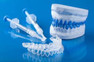 A set of whitening trays and gel on a blue backdrop in Evansville