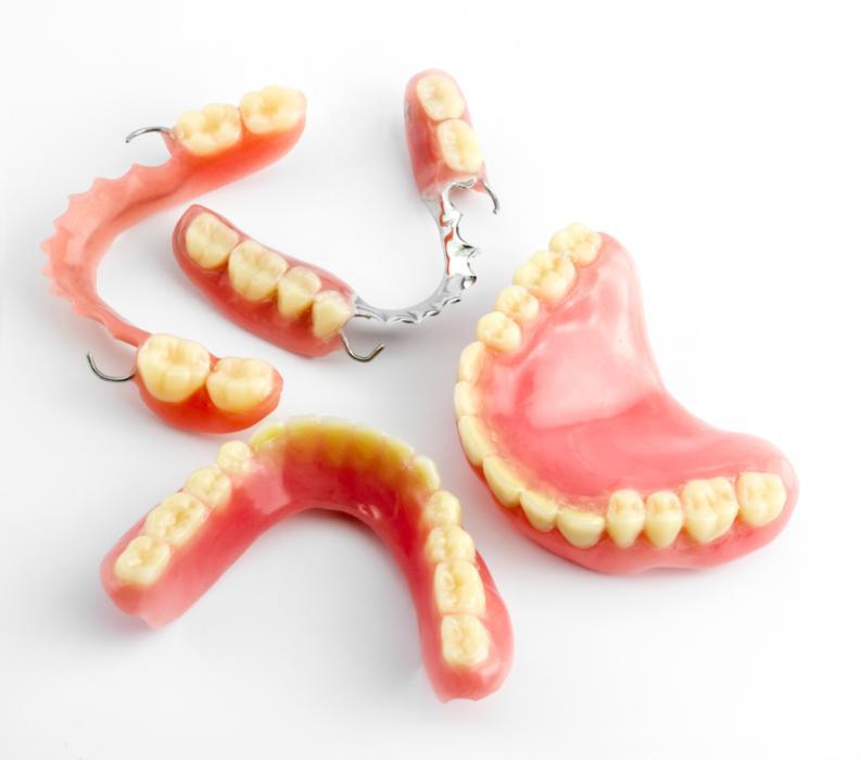 Dentures lay on a white backdrop | dentures Evansville iN