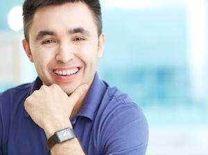 A man with braces smiles