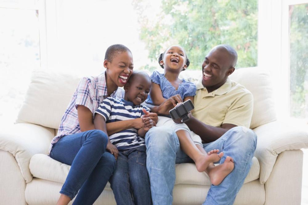 a family laughs on the couch