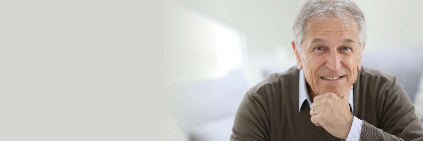 A smiling man facing the camera, reflecting satisfaction with dental implants.