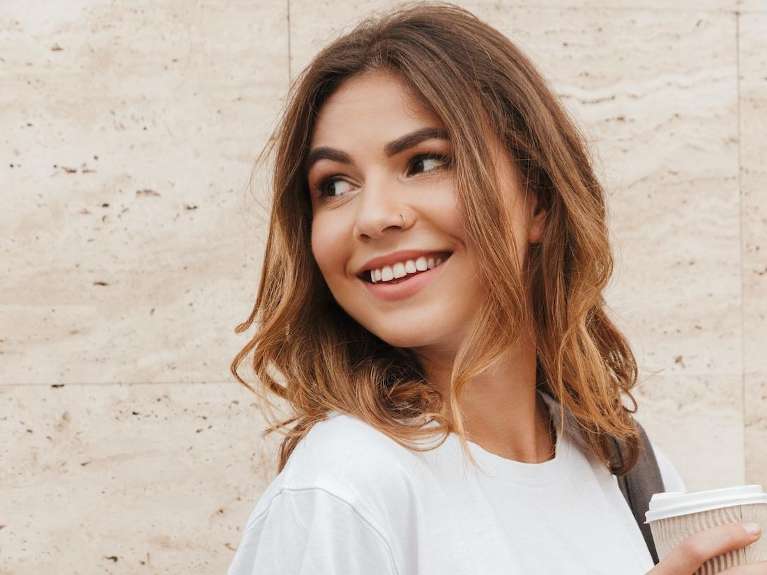 woman smiling hold a cup of coffee