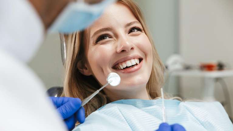 Woman undergoing a follow-up checkup after a dental implant in Newburgh IN