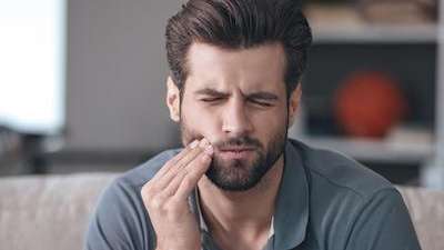 Man in Evansville IN clenching his jaw with tooth pain