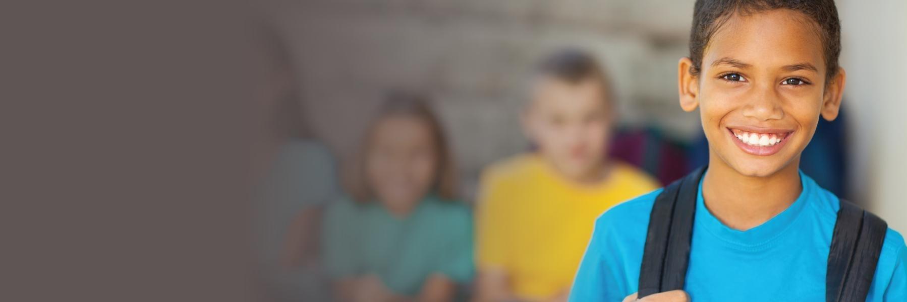 Young boy with backpack smiling 