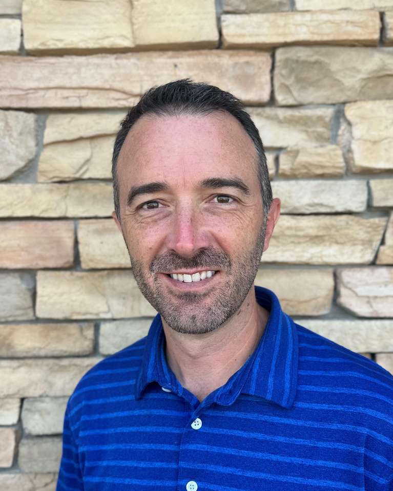 dr. chris meunier standing and smiling | dentist evansville in